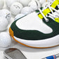 Golf shoe with green and white accents, surrounded by golf balls and a golf club on a light background.