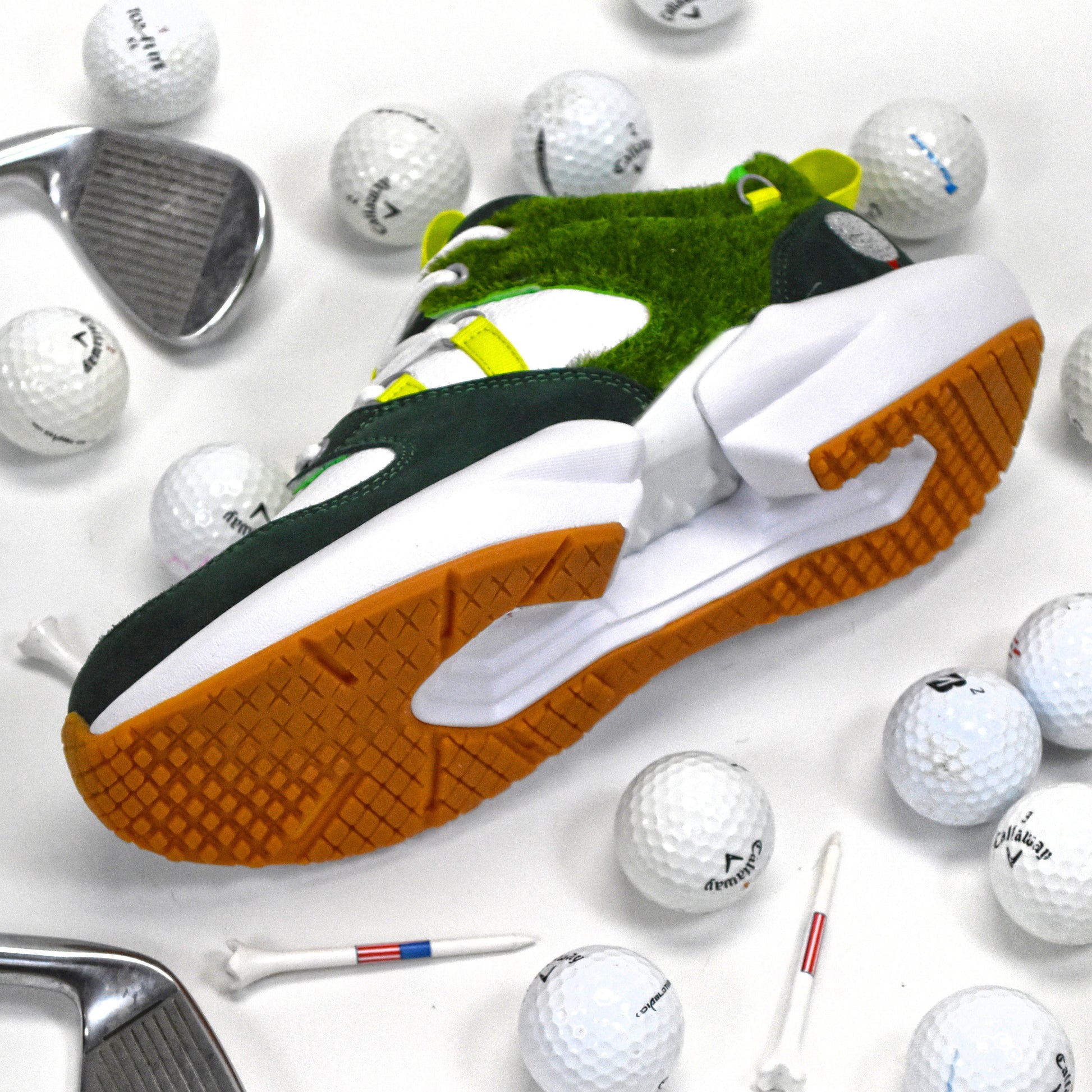 Golf shoes with green and white accents surrounded by golf balls and clubs on a white background