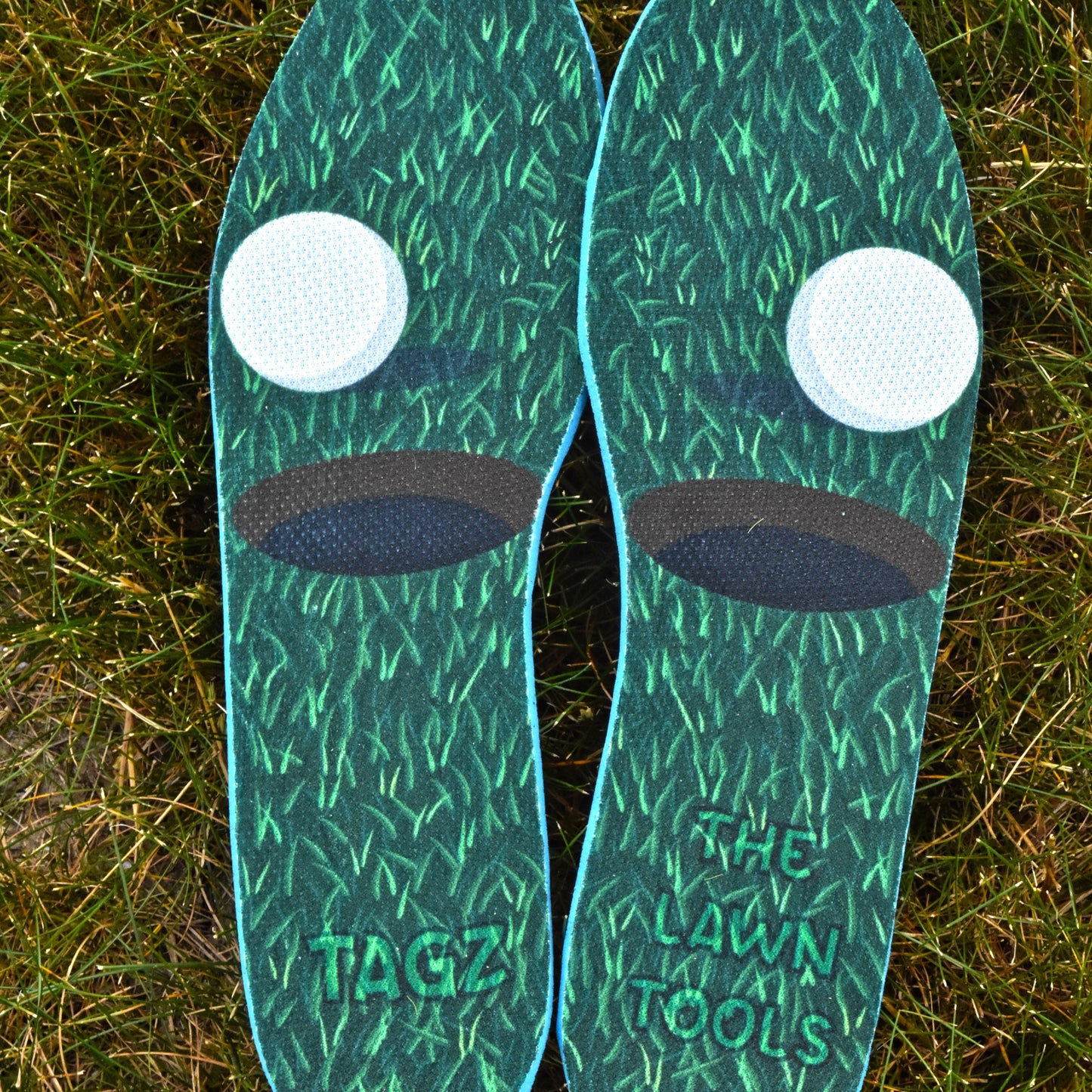 Green insoles with white dots and 'TAGZ' branding on a grass background